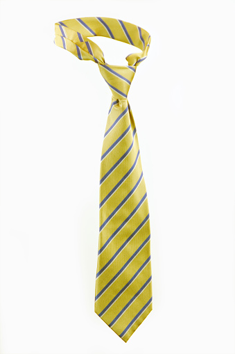 Close-up of a yellow tie with diagonal stripes.  It is tied in a Windsor and isolated on a white background. Selective focus on the center of the tie.