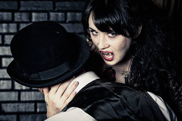 Vampire A young female preparing to bite her victim. male vampire biting his victim stock pictures, royalty-free photos & images