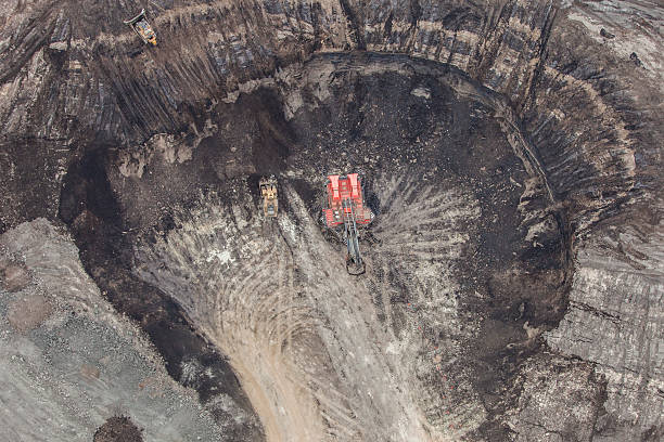 Hydrolic Mining Excavator A large power shovel excavates bitumin loaded sand from the Alberta Oilsands near Fort McMurray. oilsands stock pictures, royalty-free photos & images