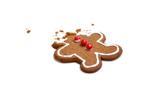 A gingerbread man's head has been eaten with only crumbs left (on white background.)