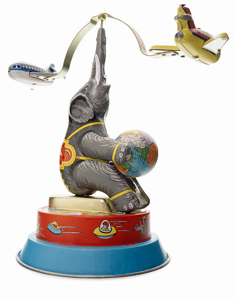 Retro Wind-Up Toy A retro wind-up toy with an elephant and an airplane isolated on white background. elephant figurine stock pictures, royalty-free photos & images