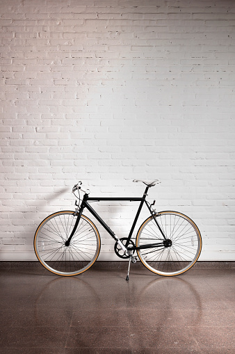 Black bicycle over a brick wall, copy space.