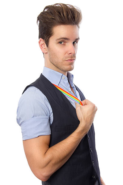Gay Pride in the Workplace A young attractive man dressed casually exposes his rainbow suspenders from underneath. The rainbow symbolizes gay pride and diversity. rockabilly hair men stock pictures, royalty-free photos & images