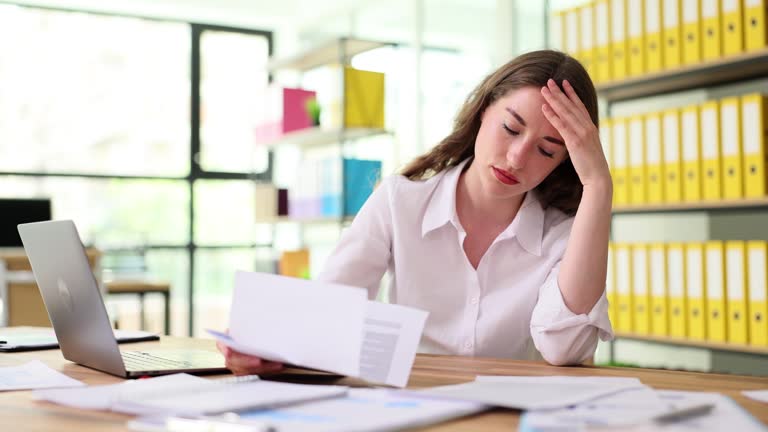 Worried frustrated woman shocked bad news or refusal to read letter in office