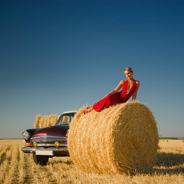 istock Girl lying on straw bale with retro car background 171586361