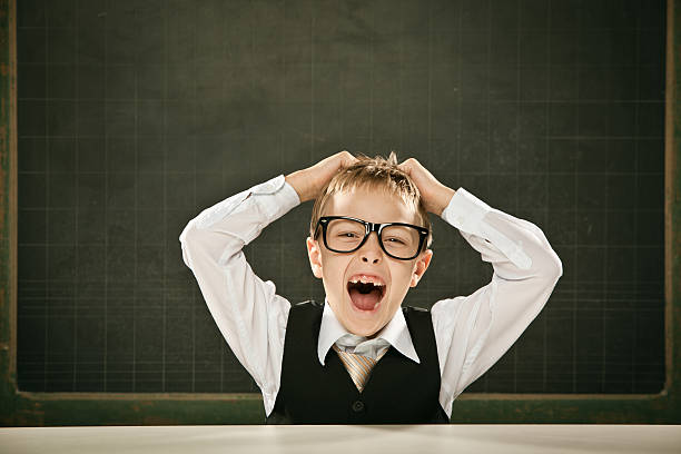istock beautiful nerd student kid with hands on head and blackboard 171586367