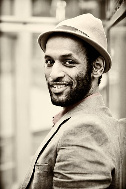 Portrait of a handsome elegant smiling man with hat toned in sepia.