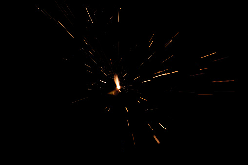 Sparkling burning sparkler on a black background. Isolated burning sparkler, fireworks for holidays Christmas, new year.