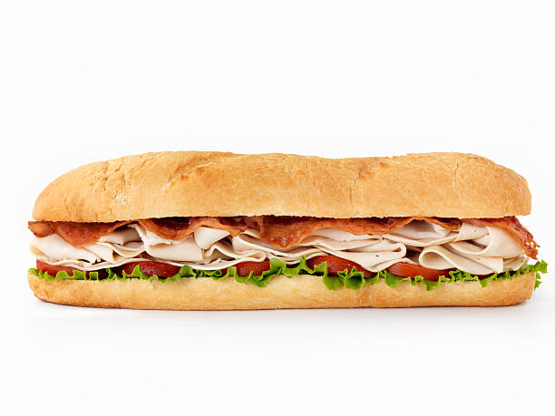 Foot long Turkey Club Submarine Sandwich 12 inch -Turkey and Bacon Submarine Sandwich with Lettuce and Tomato on Crusty Bread-Photographed on Hasselblad H3D2-39mb Camera sandwich stock pictures, royalty-free photos & images