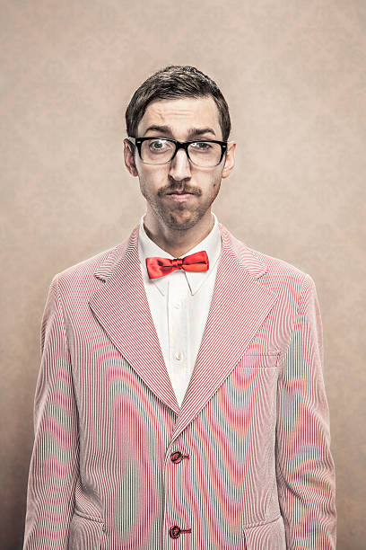 vintage fancy dressed Nerd with bow tie and glasses A retro styled image of a nerdy dorky man wearing a red and white suit and silk bow tie.  He has Horn-Rimmed glasses, mustache, and combed hair. bow tie photos stock pictures, royalty-free photos & images