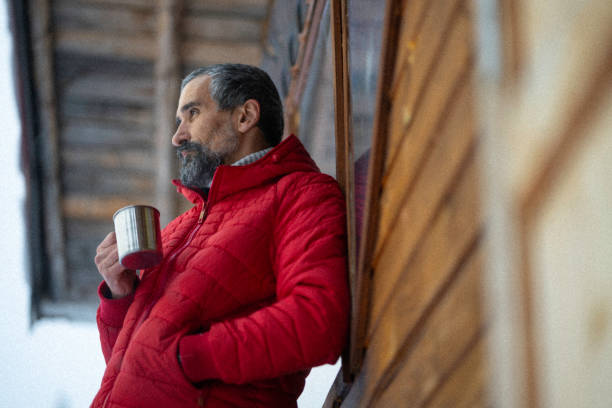 istock Cabin getaway. Man enjoys a log cabin retreat. 1715870404