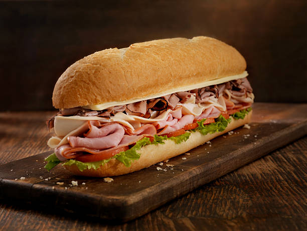Foot Long Roast Beef and Cheese Sub 12 inch -Turkey, Ham and Roast Beef Submarine Sandwich with Mozzarella, Lettuce and Tomato on a Crusty Bun- Photographed on Hasselblad H3D2-39mb Camera submarine sandwich photos stock pictures, royalty-free photos & images