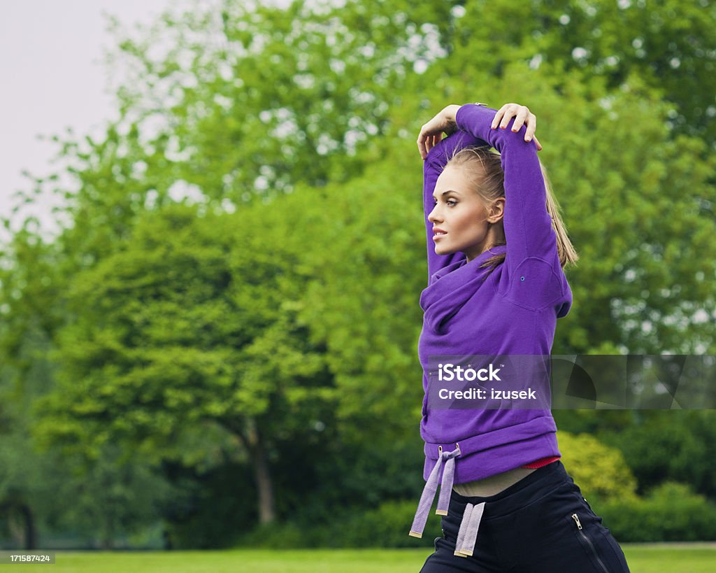 Giovane donna esercizio in un parco - Foto stock royalty-free di 20-24 anni