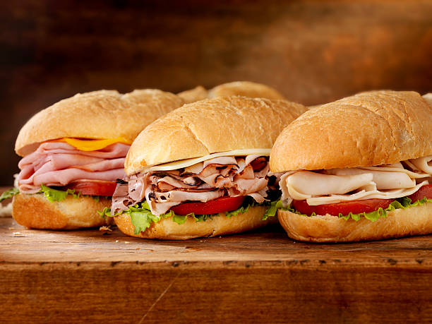 Three Foot Long Subs Three 12 inch  Submarine Sandwiches- Turkey, Ham and Cheese, Roast Beef and Swiss with Lettuce and Tomato on Crusty Buns - Photographed on Hasselblad H3D2-39mb Camera submarine sandwich photos stock pictures, royalty-free photos & images