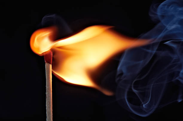 flame from a lit match Colorful smoke and flame from a burning match against a black background. match lighting equipment photos stock pictures, royalty-free photos & images