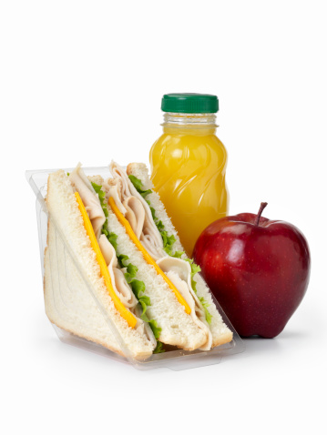 Healthy Packed Lunch with a Turkey and Cheddar Cheese Sandwich and Lettuce with Orange Juice and an Apple in a Plastic Take out Container-Photographed on Hasselblad H3D2-39mb Camera