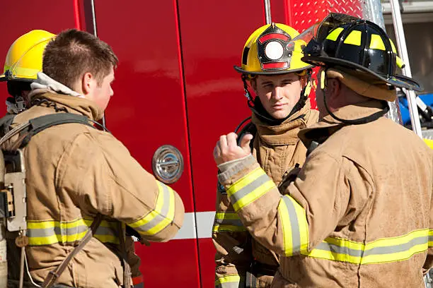 Firefighters Discussing Operational Procedures In Front of Firetruck.See more firefighter images:
