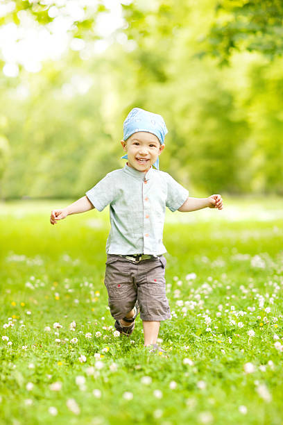 Little boy running in park towards the camera.