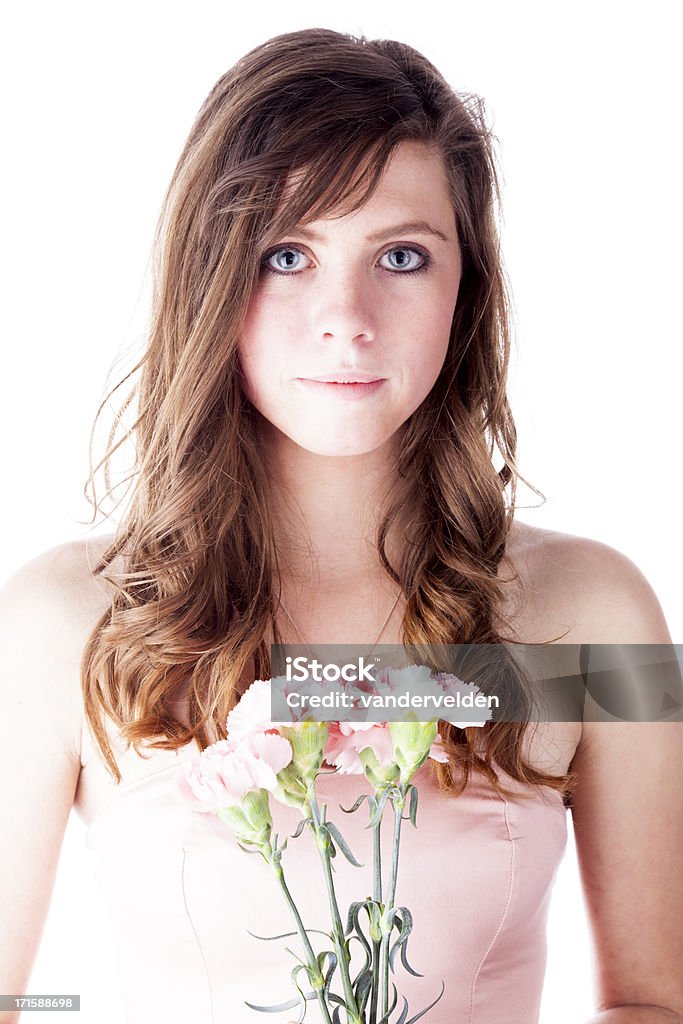 Beautiful Girl With Pink Carnations A beautiful 17-year-old brunette in a pink dress holding a spray of pink carnations. Isolated on white in the studio. 16-17 Years Stock Photo