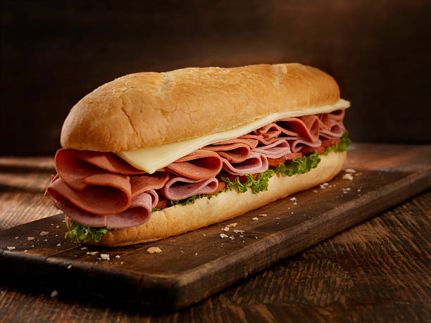 Foot Long Pizza Sub 12 inch - Salami, Pepperoni and Mozerella Cheese Submarine Sandwich with Lettuce and Tomato on a Crusty Bun- Photographed on Hasselblad H3D2-39mb Camera submarine sandwich photos stock pictures, royalty-free photos & images