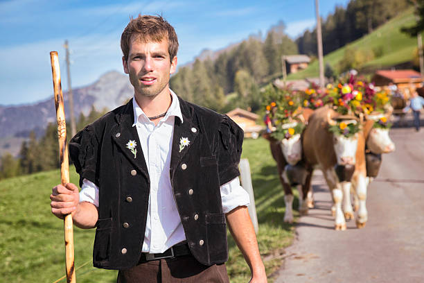schweizer cowboy in traditioneller kleidung, die seine einrichtung rind - cow swiss culture switzerland cattle stock-fotos und bilder