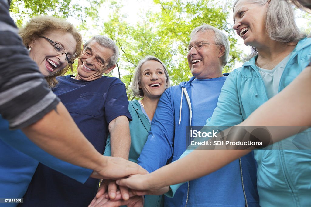 Grupa seniorów wprowadzenie ręce razem jako zespół - Zbiór zdjęć royalty-free (Aktywni seniorzy)