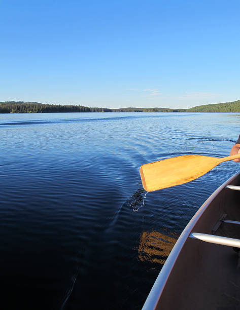 istock Man paddles canoe on tranquil lake 171589082
