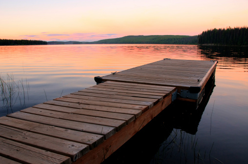 A dock on tranquil Beaver Lake, located near Kelowna, British Columbia, at sunset.