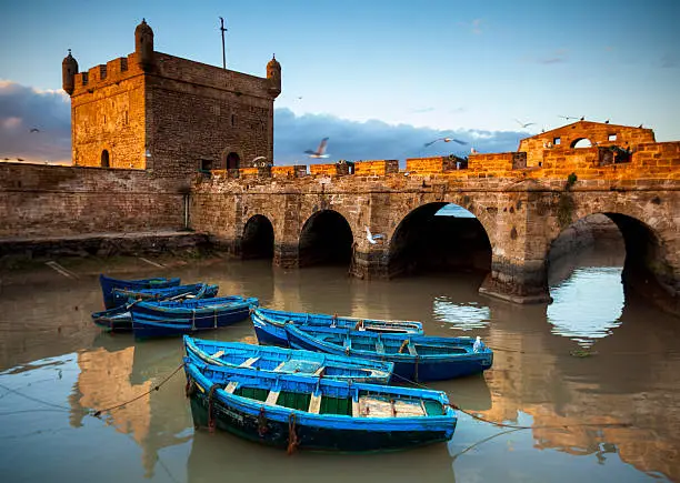 Fishing boats and historical bastion in Essaouira, Morocco.