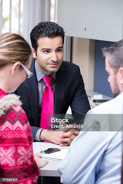 Stylish Banker Discussing A Loan With Young Couple Stock Photo - Download Image Now - Office, Business Person, Customer