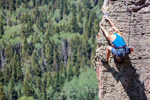 femme alpiniste sur une paroi rocheuse - rock climbing mountain climbing women achievement photos et images de collection