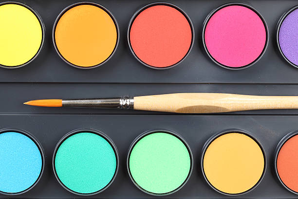 Watercolor paints and paintbrush
