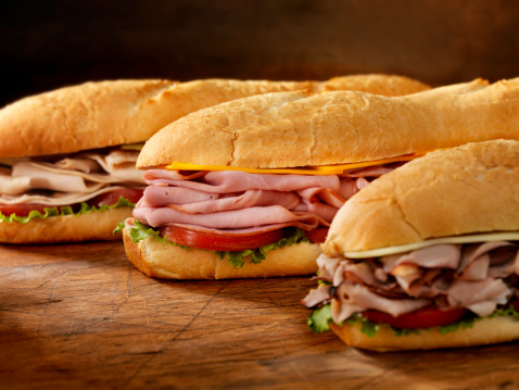 Three 12 inch  Submarine Sandwiches- Turkey, Ham and Cheese, Roast Beef and Swiss with Lettuce and Tomato on Crusty Buns - Photographed on Hasselblad H3D2-39mb Camera
