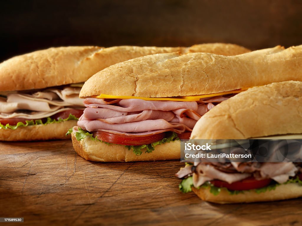 Three Foot Long Subs Three 12 inch  Submarine Sandwiches- Turkey, Ham and Cheese, Roast Beef and Swiss with Lettuce and Tomato on Crusty Buns - Photographed on Hasselblad H3D2-39mb Camera Submarine Sandwich Stock Photo