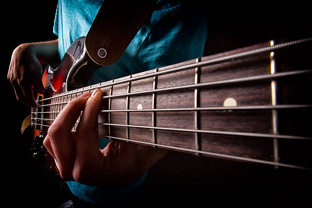 guitarra baja jugador - bass guitar fotografías e imágenes de stock