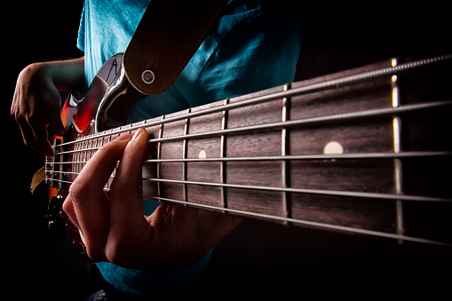 Close up guitar bass string details , four iron strings, white and black color. string instrument , electric guitar bass macro from body to neck. Music Close up. Musical instruments details