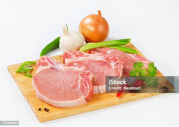 Raw Schweinekoteletts Mit Gemüse Garnieren Auf Ein Schneidebrett Stockfoto und mehr Bilder von Blatt - Pflanzenbestandteile
