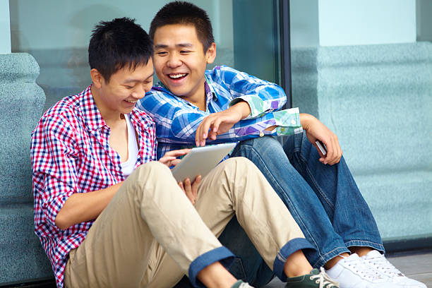 istock happy young men using tablet together outdoor 171589614