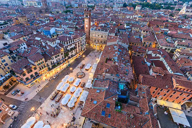 Piazza delle Erbe seen from the Torre dei Lamberti, the tallest building of Verona. The square is the oldest of Verona and is the heart of the city, today as in Roman times. It is surrounded by historical palaces, and even today hosts a permanent market, mainly of fruit and vegetables but also with souvenirs of the city. Verona, Italy. 