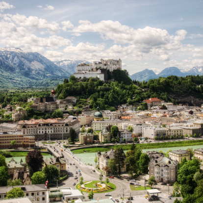 Salzburg's famous old town and emerald-colored Salzach River with northern Alpine ridge in the background.   