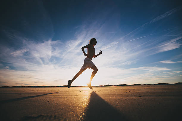 männliche läufer für ein trainings-lauf bei sonnenuntergang - langstreckenlauf stock-fotos und bilder