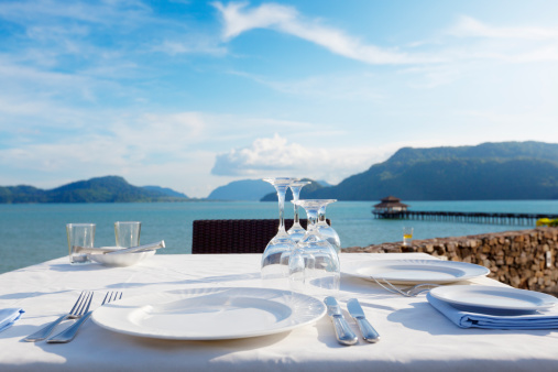 fine dining table setting in a restaurant with beautiful ocean view in langkawi, malaysia.