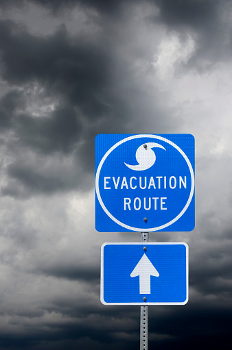A Directional Sign in Front of Storm Clouds indicating the Storm Evacuation Route.