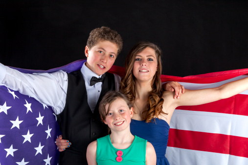 Brother and his sisters with the American flag.