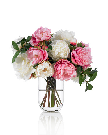 A pink peony bouquet in a tall glass vase. Shot against a bright white background. There is a path which may be used to delete the reflection if desired. Extremely high quality faux flowers.