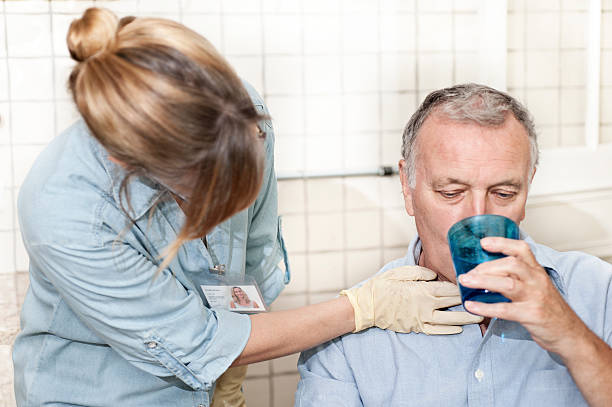 Healthcare worker checking man's throat stock photo