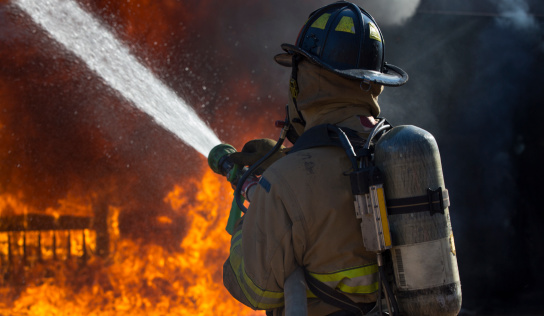 Two-man firefighters use Twirl water fog-type fire extinguishers to fight the fire flame from gas exposure to prevent the fire from spreading out. Firefighter and industrial safety concept.