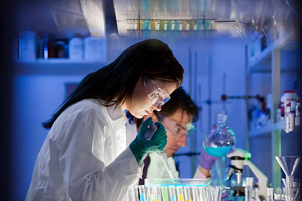 groupe scientifique en laboratoire - scientist research test tube lab coat photos et images de collection