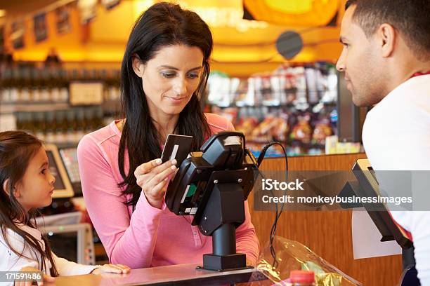 Madre Pagar Para La Familia De Compras En El Momento De La Compra Foto de stock y más banco de imágenes de Tarjeta de crédito