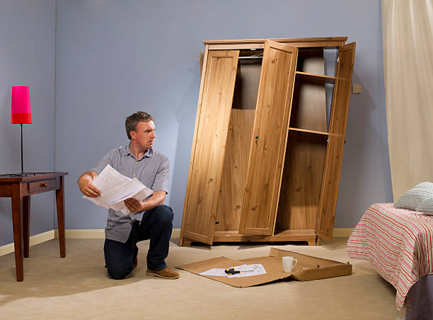 flatpack furniture man has another look at his self assembly instructions instruction manual photos stock pictures, royalty-free photos & images